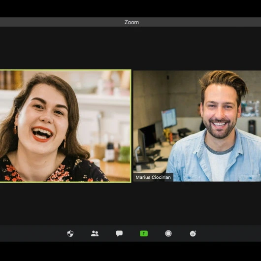 Zoom video call featuring a smiling woman on the left and a smiling man on the right.