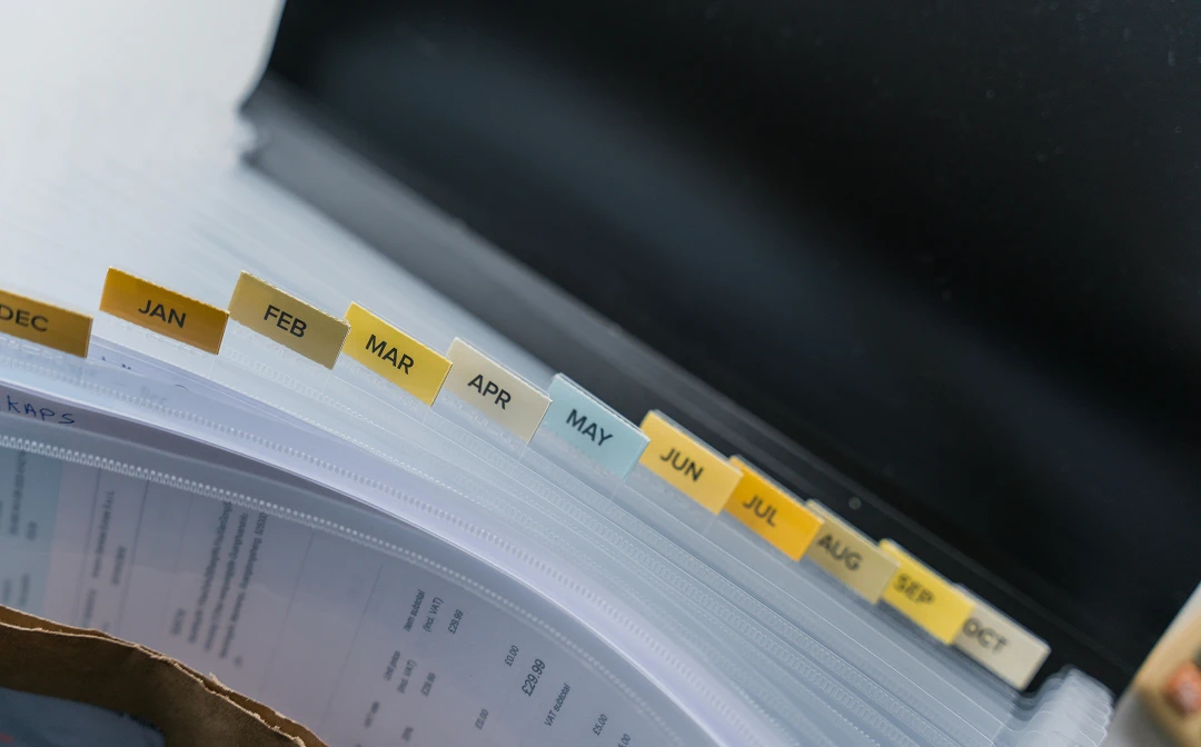 File folder with labeled documents organized by month