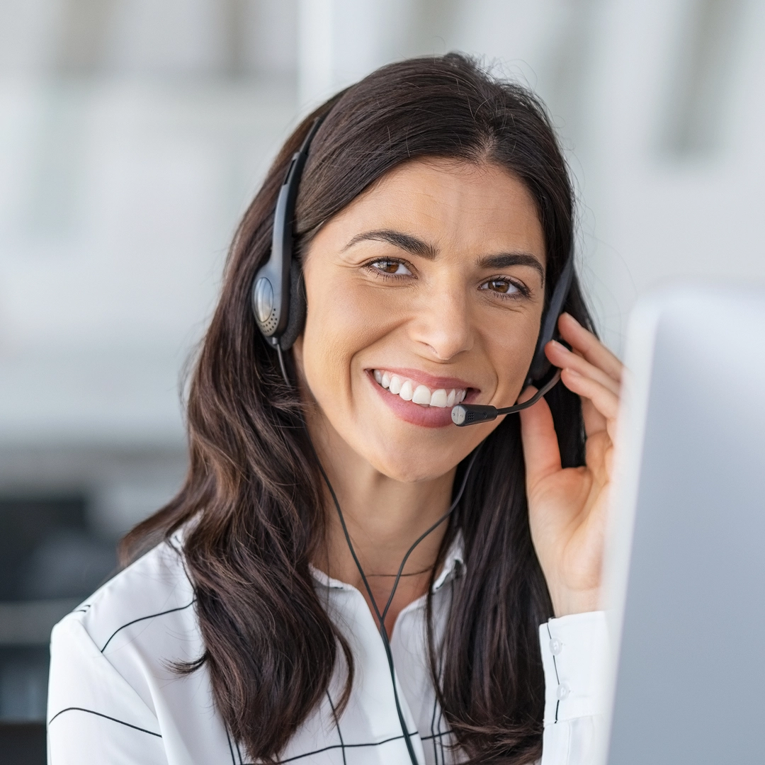 Smiling female customer support representative wearing a headset, offering friendly and professional service