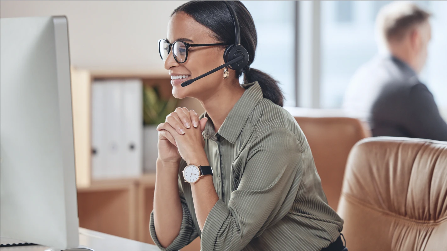 Cheerful female customer service representative wearing a headset during a call