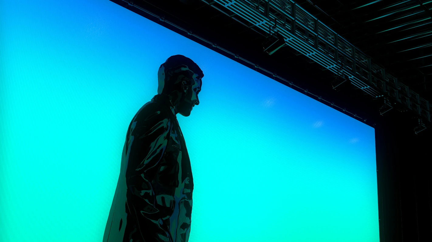 A glossy dark human statue against a vibrant gradient background