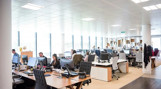 Busy open-plan office with customer support agents working at their desks