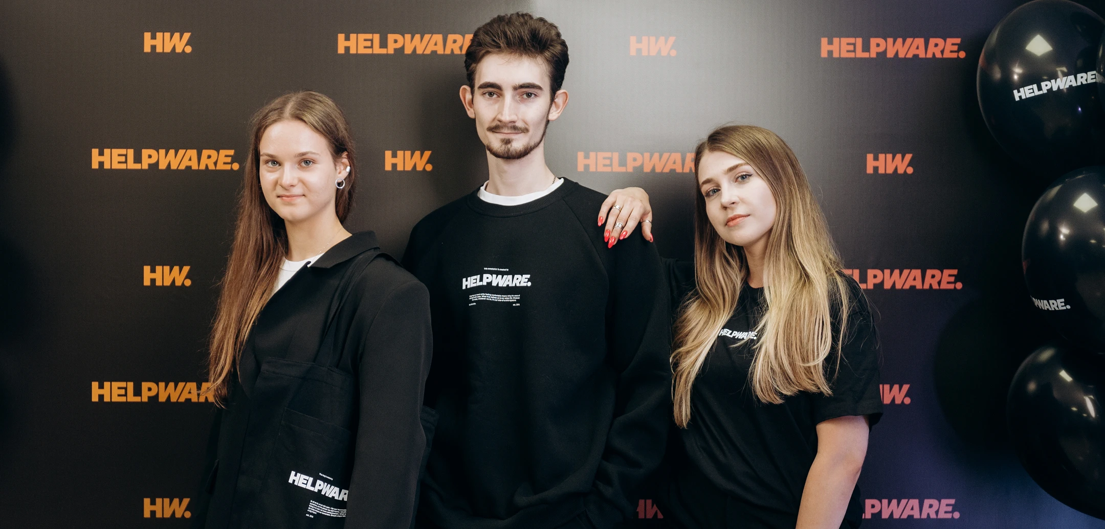 Three Helpware team members wearing branded company clothing