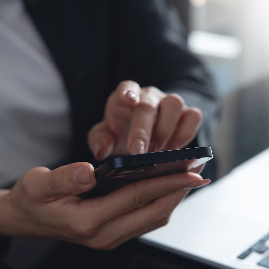 Woman's hands holding and using a smartphone