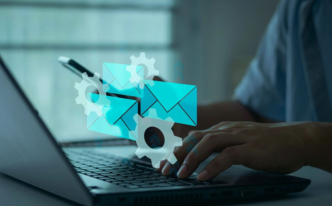 Hands typing on laptop with overlaid email and gear icons representing CRM integrations