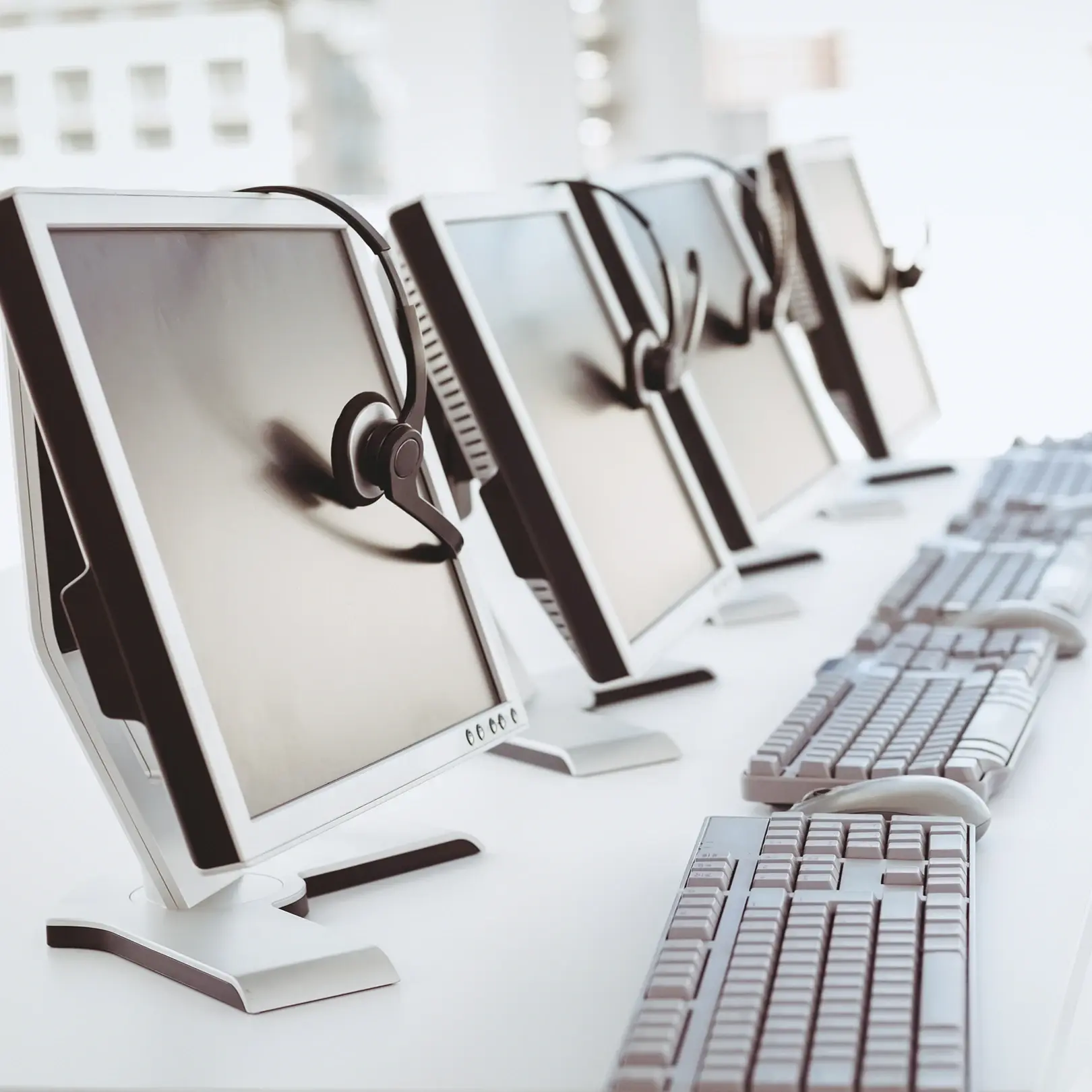 Row of computer workstations with headsets in a call center in Austin
