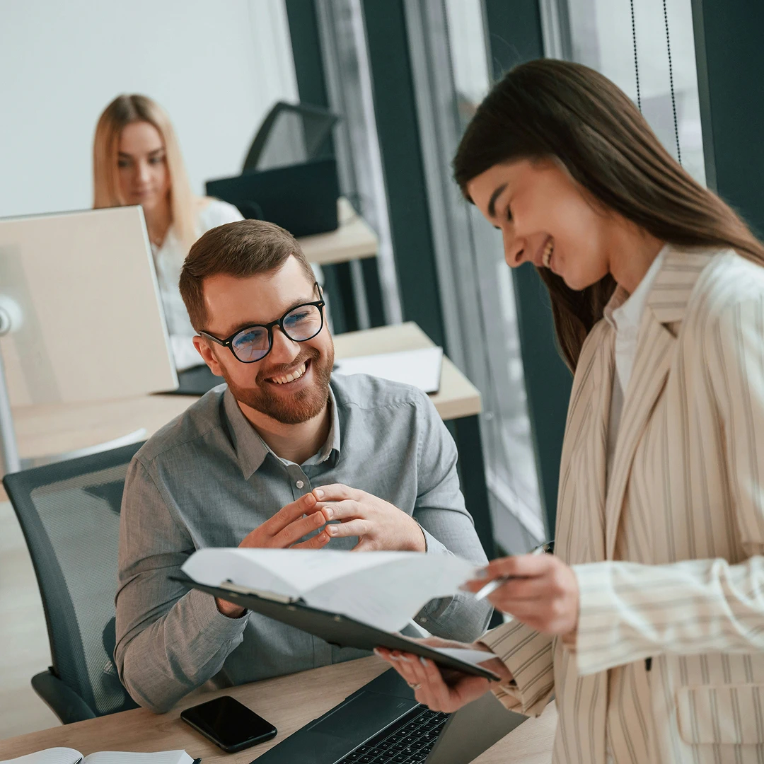 Two colleagues reviewing documents in a modern office