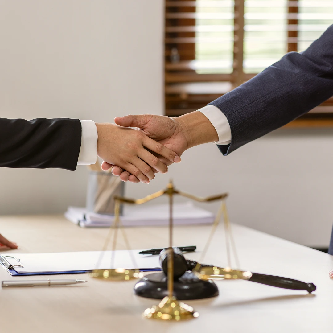 Close-up of two men in suits shaking hands