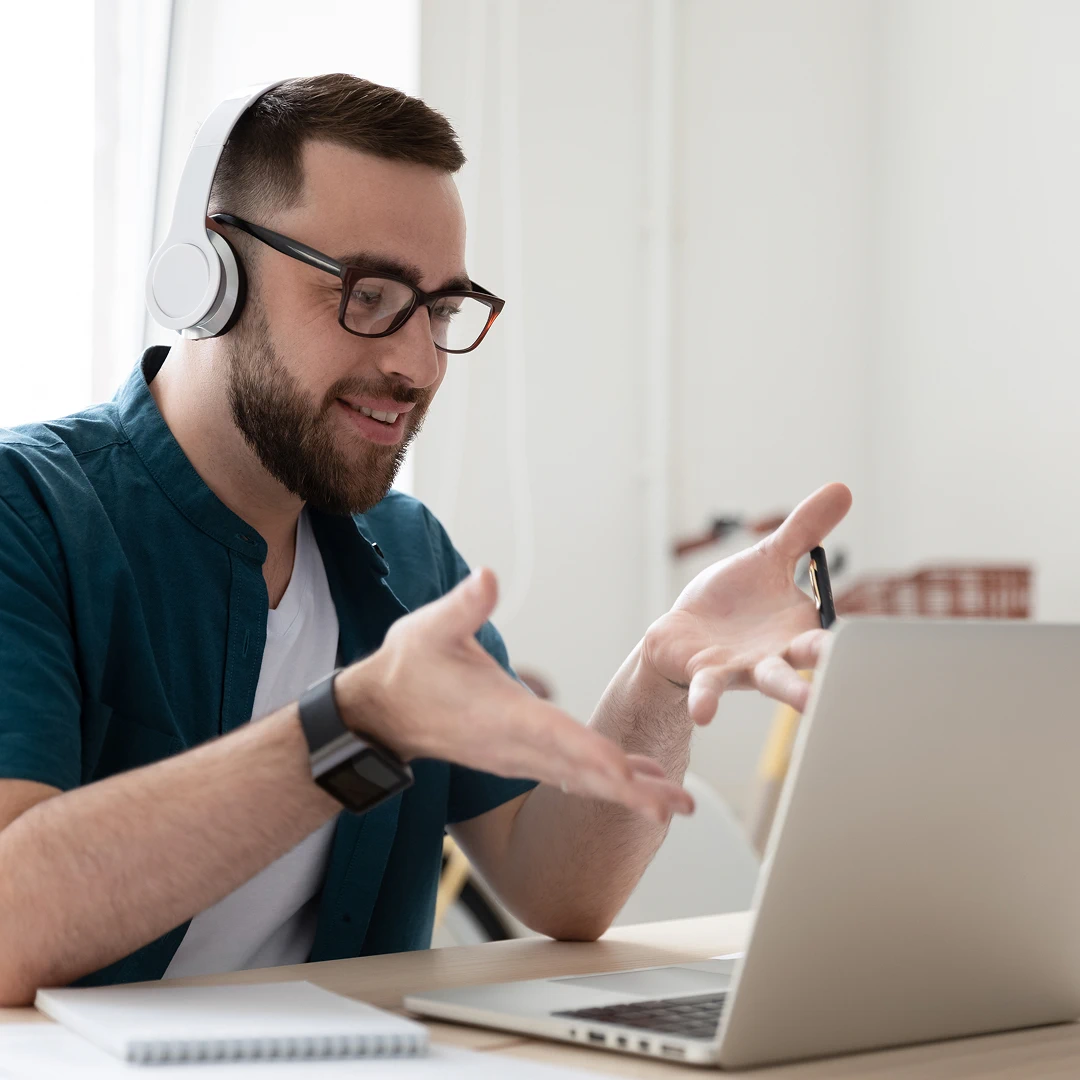Man with headphones gesturing during a video conference