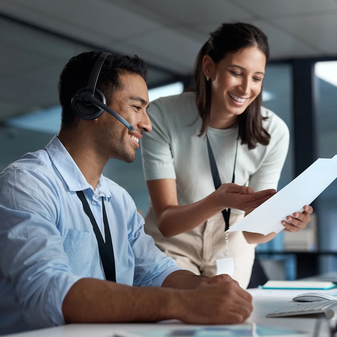 Two customer support colleagues reviewing a document at work