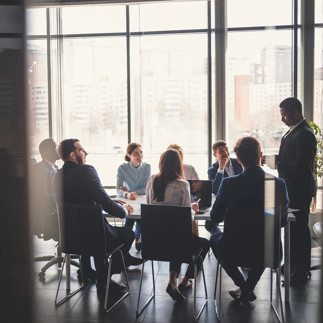 A group of professionals collaborating in a bright conference room, with a focus on teamwork and a supportive work environment