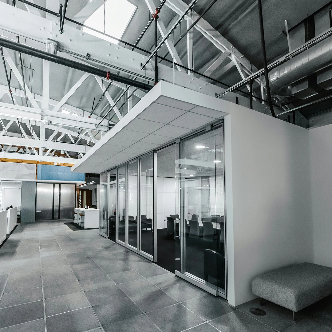 A modern, bright call center with a glass-walled conference room