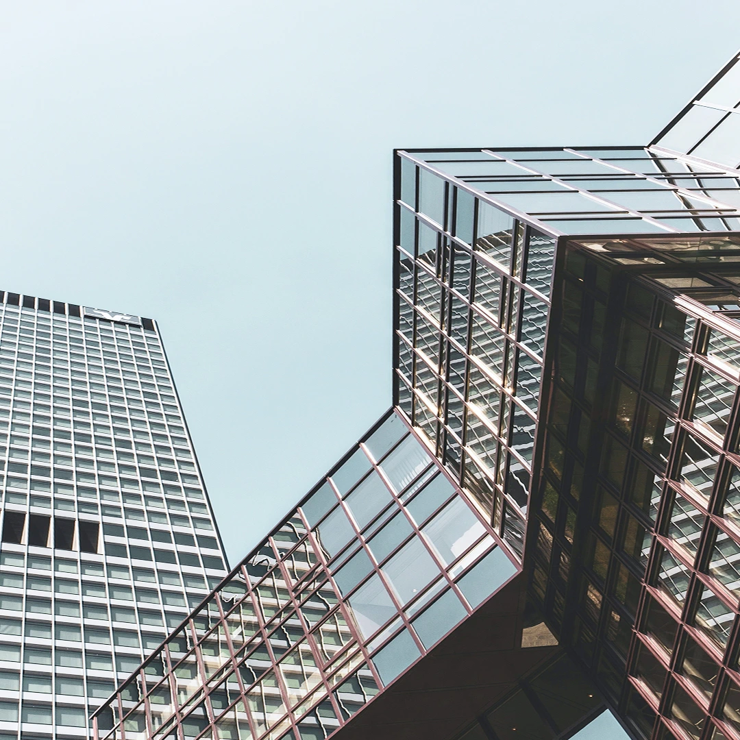 Two modern skyscrapers against a light blue sky