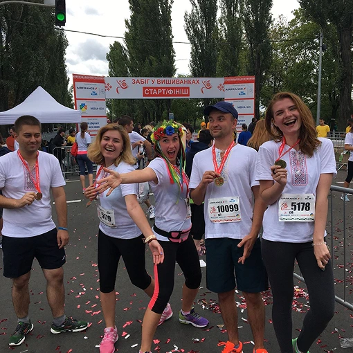 Five Ukrainian Helpware employees celebrate the finish of the marathon in traditional embroidered shirts