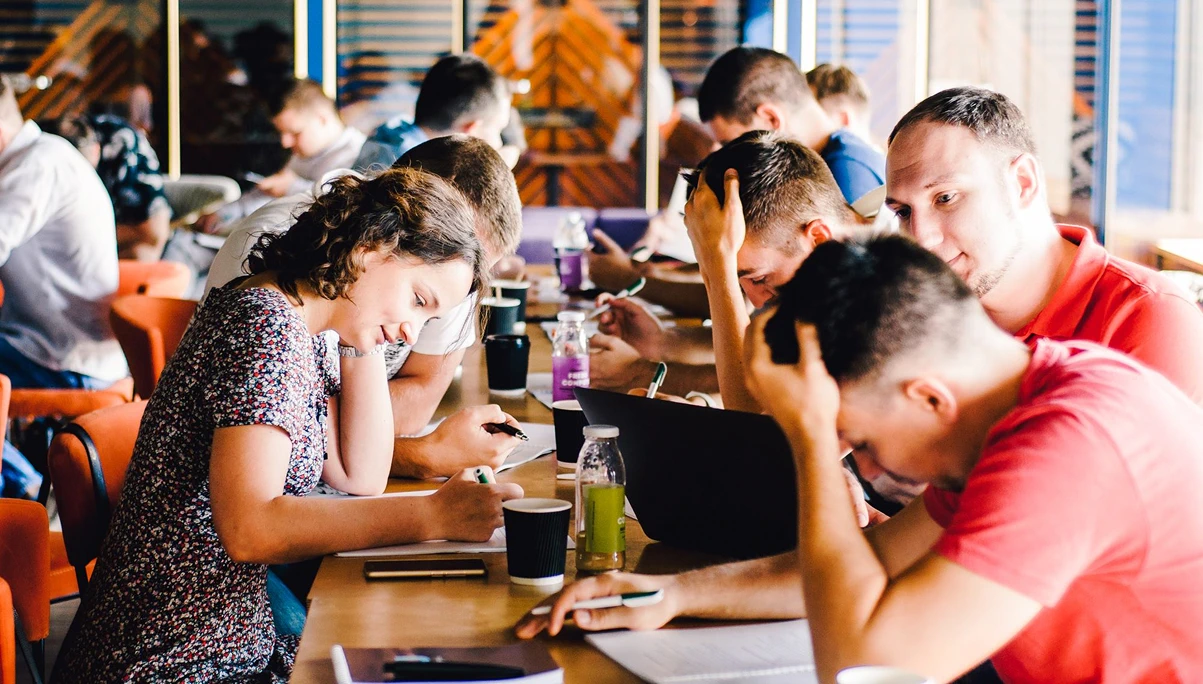 Group of young professionals working together at long table