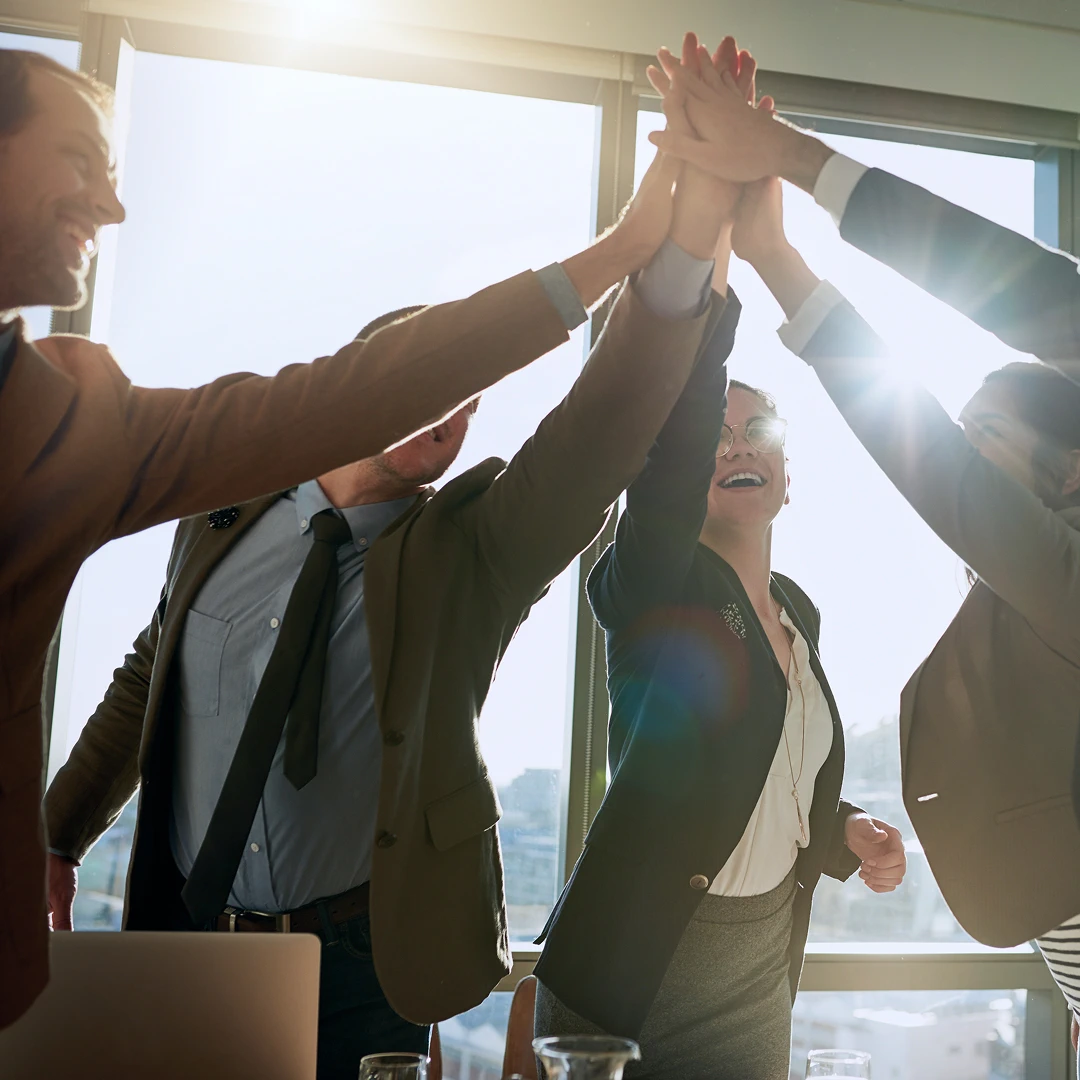 Business colleagues form a circle and raise their arms for a high-five