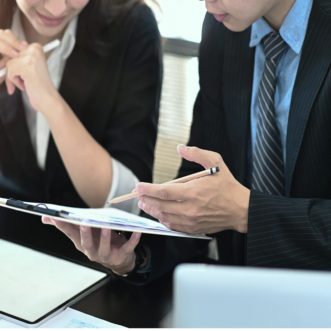 Businesspeople collaborating and analyzing charts and graphs on a document