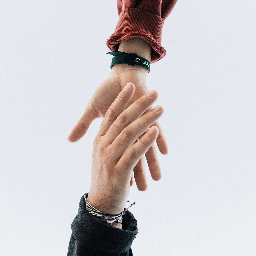 Two hands reaching for one another against a plain white background
