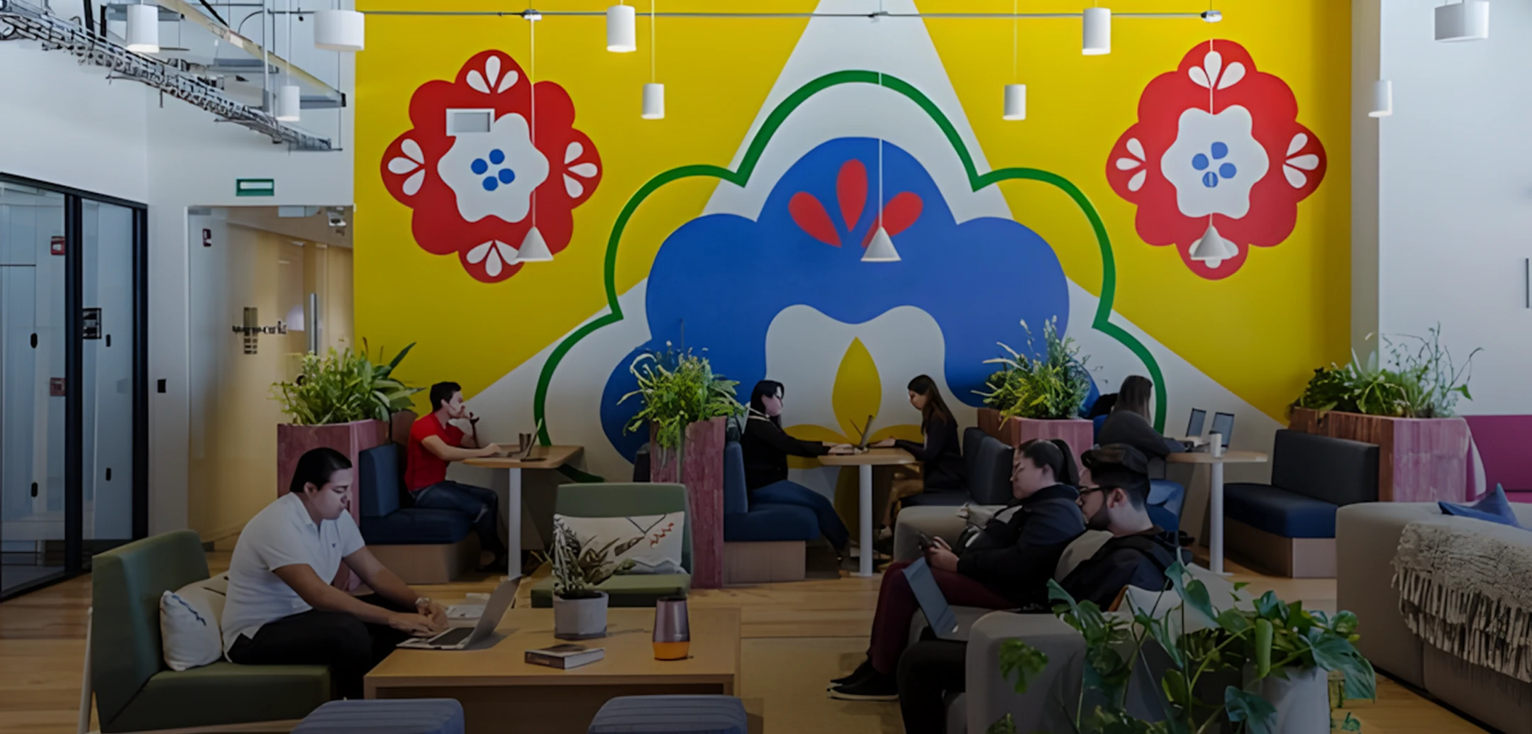 Collaborative office space with team members working and artistic wall mural