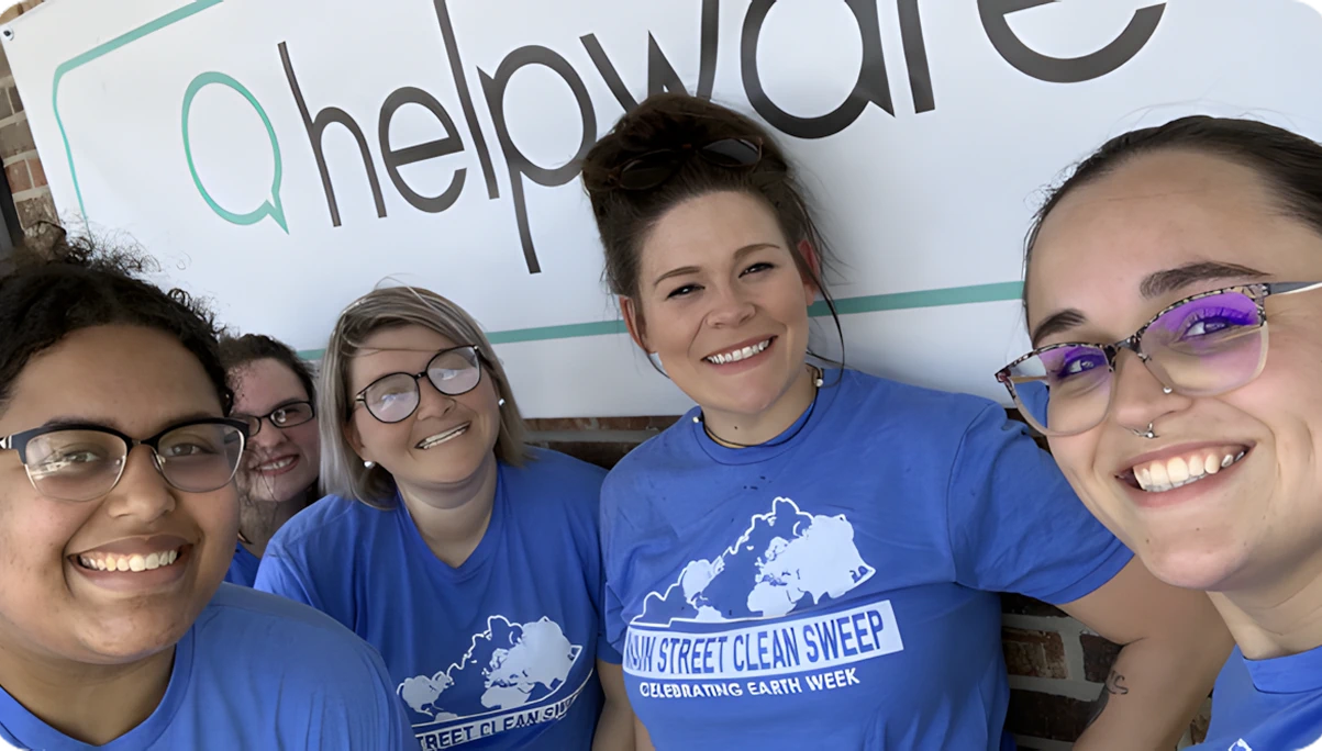 Helpware team members in blue shirts smiling for a selfie