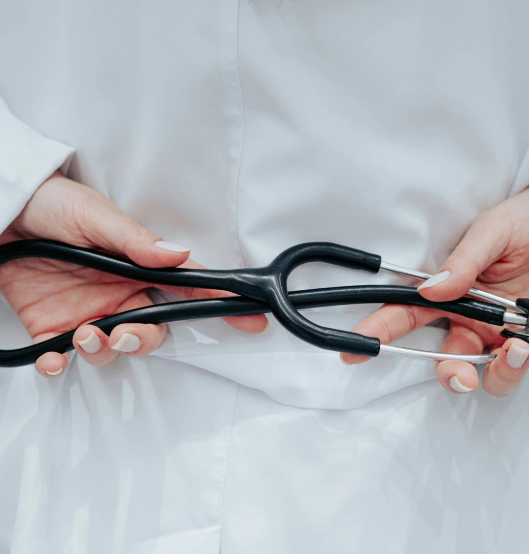 female nurse holding a stethoscope behind her back