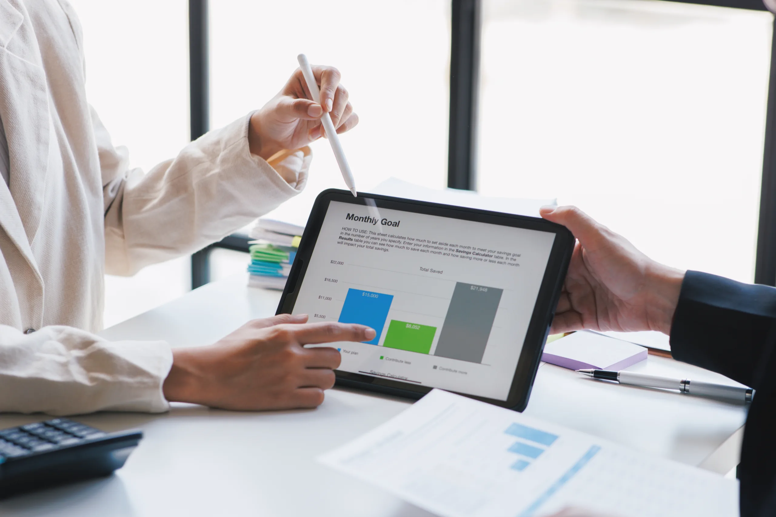 Two people are analyzing a financial chart on a tablet