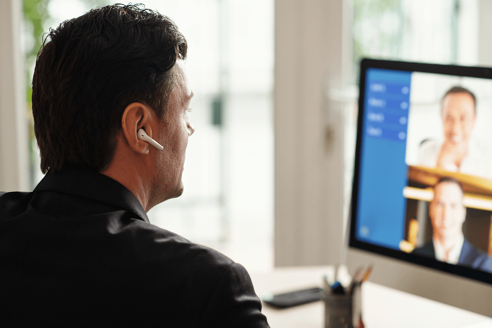 A man who works remotely is attending a work video call.