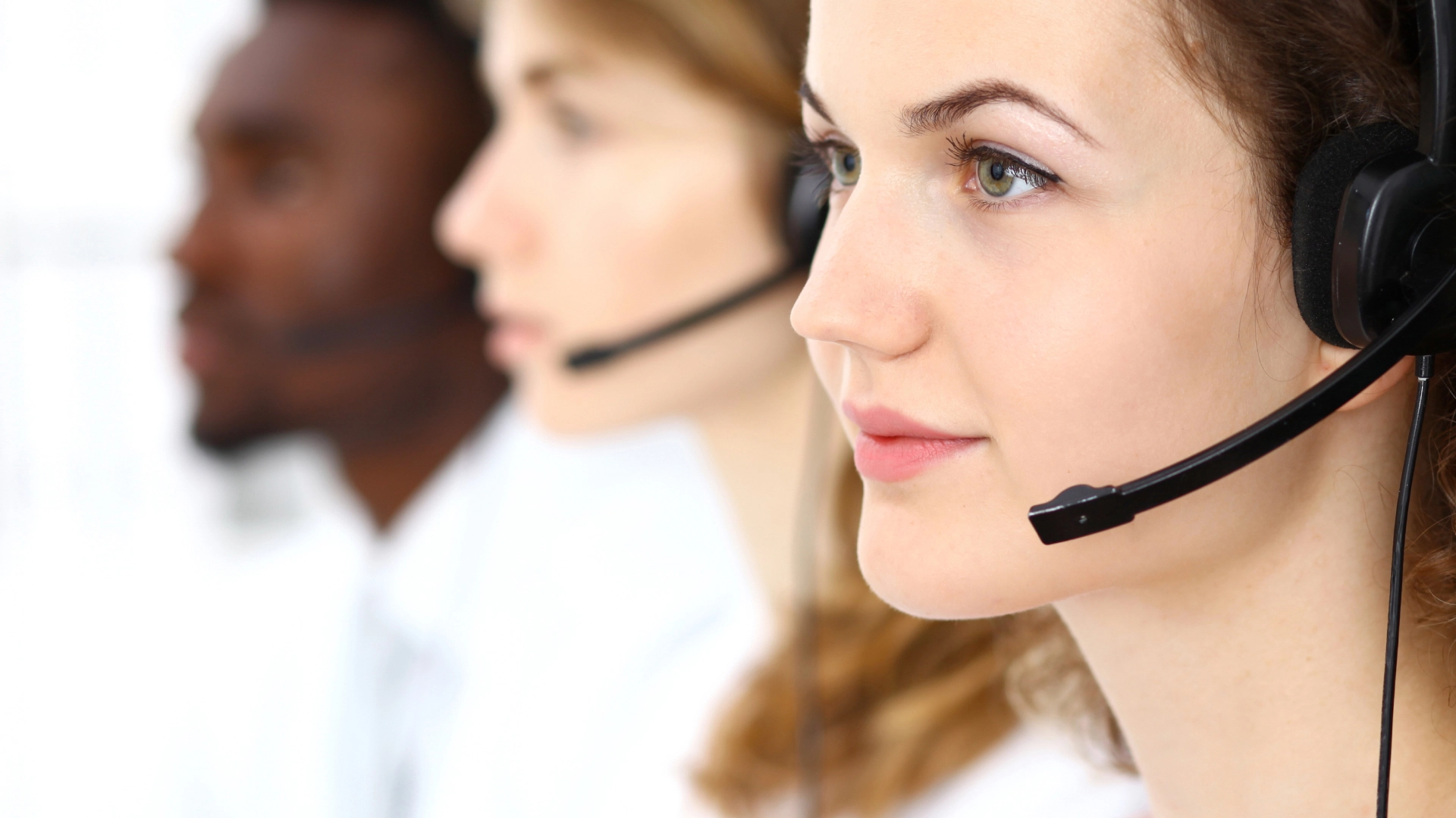 Customer service professionals, wearing headsets, are ready to assist customers.