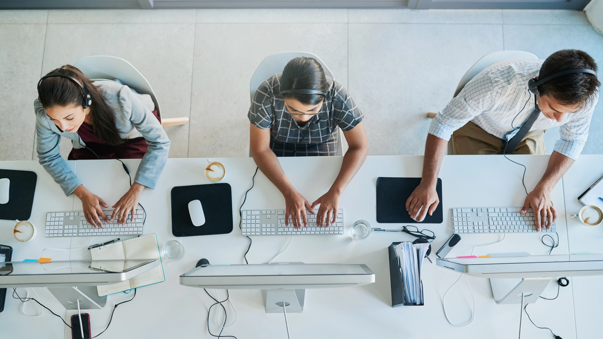 Customer support team working diligently at their computers, wearing headsets to assist customers.