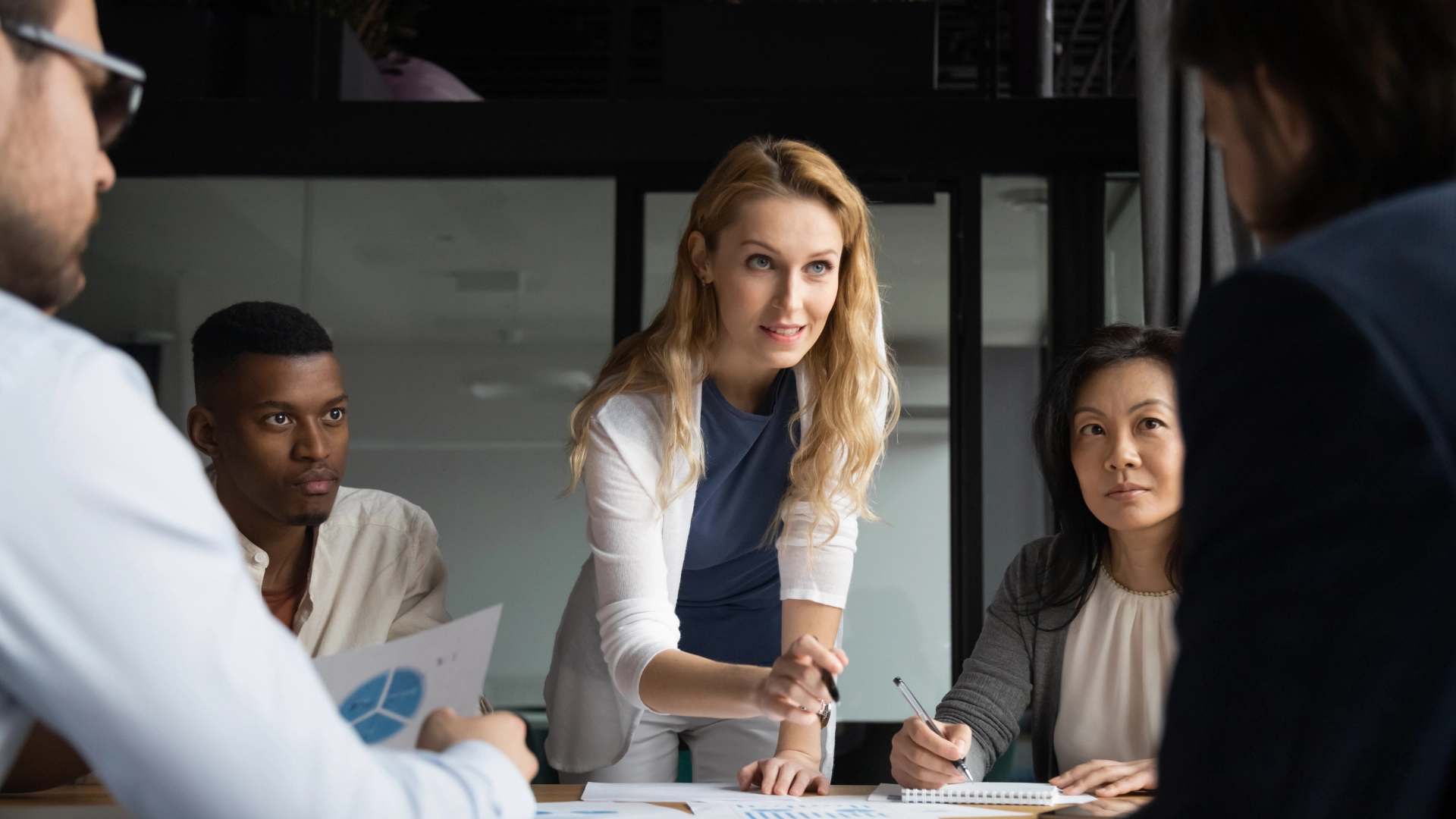 Diverse group of professionals collaborating in a modern meeting room.