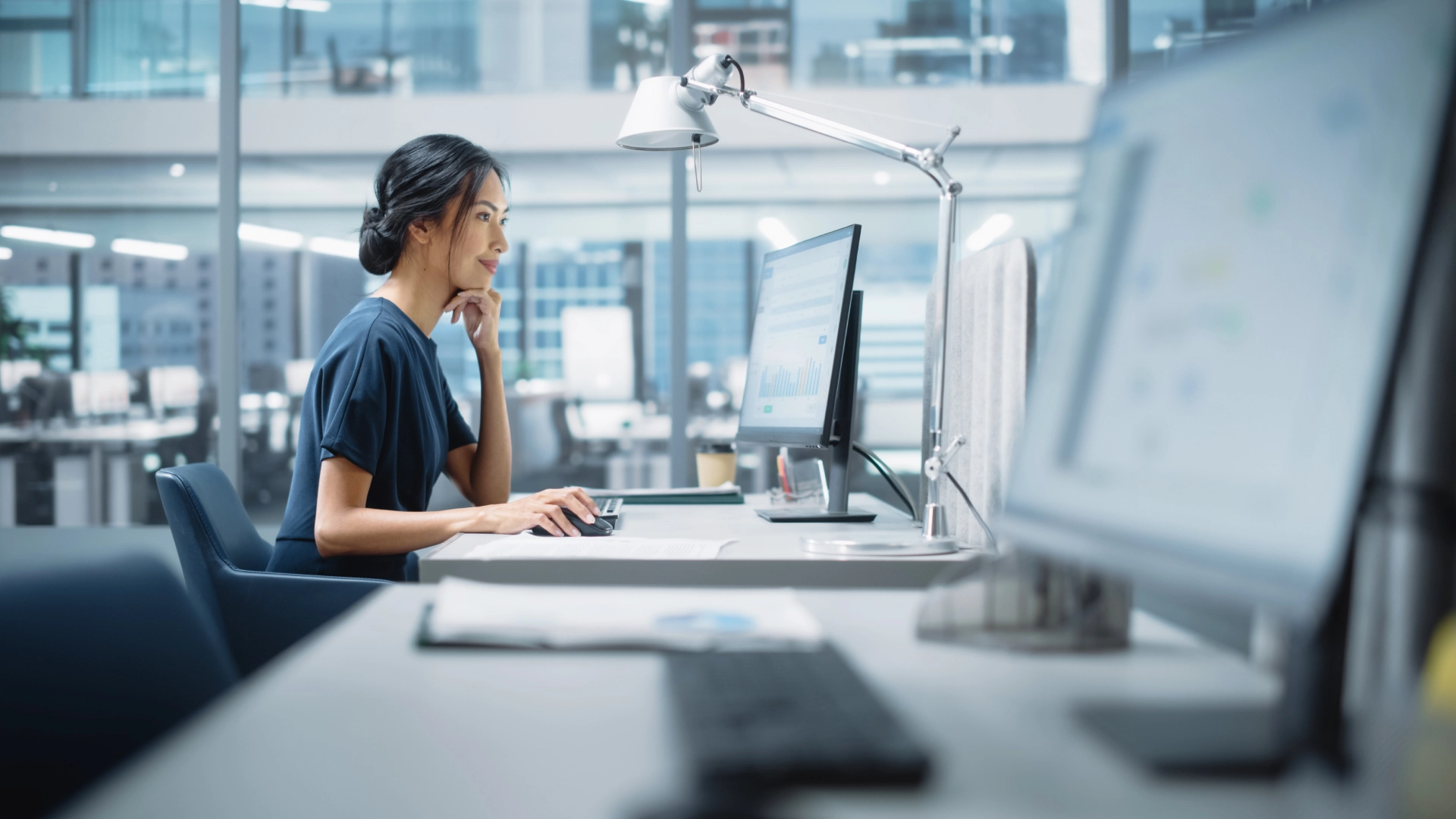 Businesswoman works at computer in a modern office.