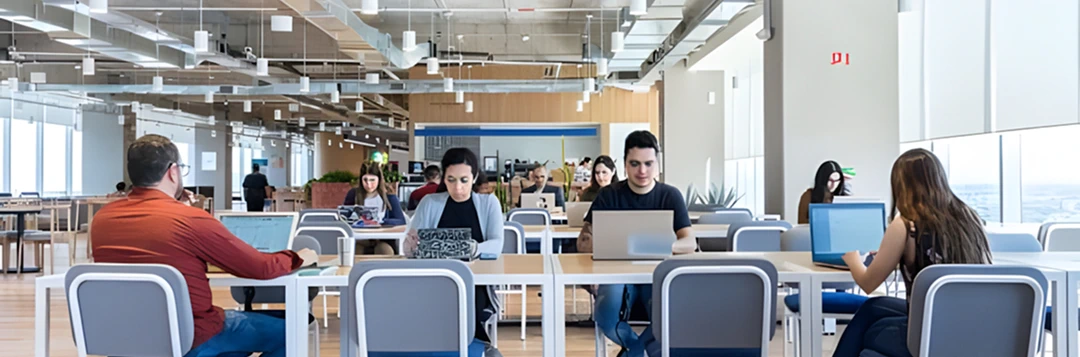 Modern, open-concept office space with employees working on laptops